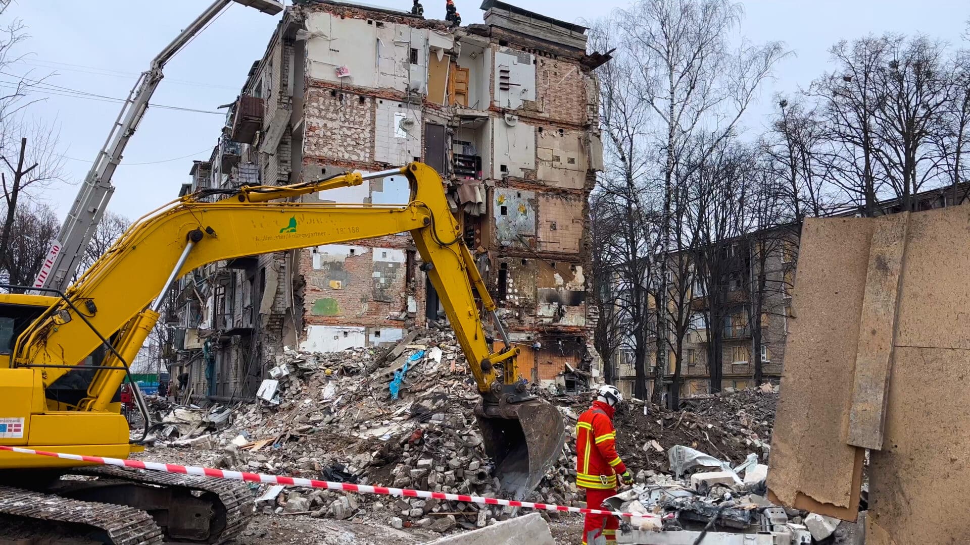 Excavator demolishing a damaged building with construction workers and debris in Hagerstown, MD, highlighting safe and efficient demolition services by Antietam Restoration.